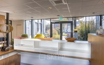 Reception area at Techniekweg 15, Gorinchem, ready for office space rental with modern furnishings and large windows inviting natural light.