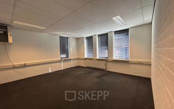 Unfurnished office space with large windows and carpeted floor at Techniekweg 15, Gorinchem, ideal for office space rental.