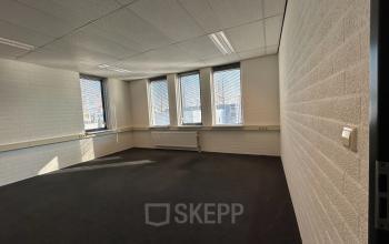 Interior view of an unfurnished office space at Techniekweg 15, Gorinchem, with large windows allowing natural light.