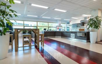 Spacious office pantry with wooden tables, chairs, and large windows at Groningenweg 8 8, Gouda, ideal for office space rental.