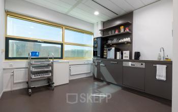 Furnished office pantry with shelves, sink, and coffee machine in Gouda, ideal for office space rental at Groningenweg 8 8.