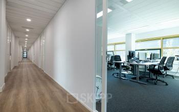 Bright office space available for rent at Groningenweg 8 8, Gouda, featuring a modern workspace with multiple desks and chairs, ideal for business professionals.