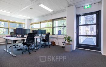 Modern office space in Gouda with desks, chairs, and large windows; ideal for office space rental.