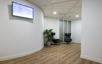 Office space at Groningenweg 8 8 in Gouda, featuring a modern reception area with comfortable seating and digital display, available for office space rental.