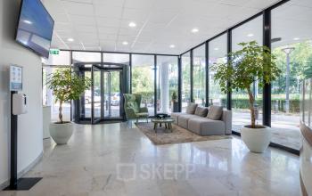 Spacious reception area at Groningenweg 8 8, Gouda, ideal for office space rental with seating and large windows.