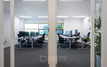 Spacious office at Groningenweg 8 8, Gouda, with modern workstations set up for rent. Large windows and ergonomic chairs create a welcoming environment for office space rental.