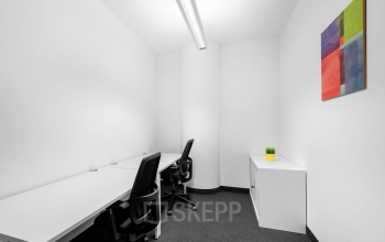Modern corner workstation in the office space rental at Brückenkopfgasse 1, Graz, featuring ergonomic chair and bright art on the wall.