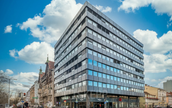 Modern office building at Brückenkopfgasse 1 in Graz offering office space rental, with glass façade and urban backdrop.