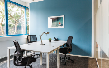 Modern office space rental at Waagner-Biro-Straße 47, Graz, featuring a clean desk with chairs and bright natural light.