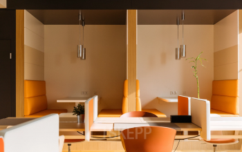 Modern office space rental at Waagner-Biro-Straße 47, Graz, featuring stylish furniture and warm color accents.