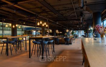 Modern Groningen office space rental at Winschoterdiep 50 featuring stylish lighting and communal tables.