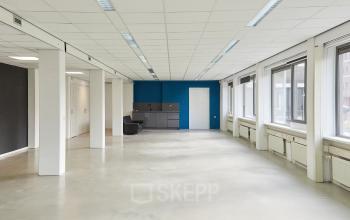 Bright, unfurnished office space at Schweitzerlaan 12, Groningen, featuring large windows and a small kitchenette area, perfect for office space rental.