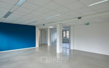 Unfurnished interior office space with a blue accent wall and large windows at Schweitzerlaan 12, Groningen, available for rent office space.
