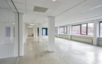 Spacious office space available for rent at Schweitzerlaan 12, Groningen, featuring large windows and an open floor plan for optimal workspace layout.