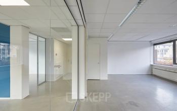 Bright, unfurnished office space available for rent at Schweitzerlaan 12, Groningen with large windows and glass partitions.