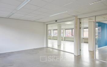 Spacious interior view of an unfurnished office space at Schweitzerlaan 12, Groningen, available for rent. Large glass partitions offer natural light, ideal for customizable office space rental.