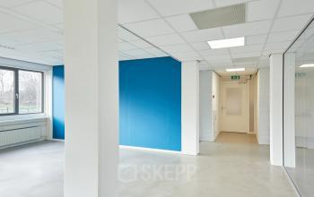 Interior of an unfurnished office space with blue accent wall at Schweitzerlaan 12, Groningen, available for office space rental.