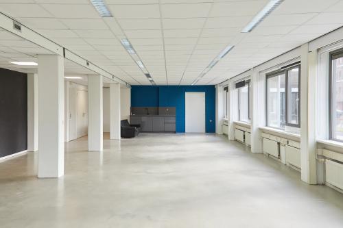 Bright, unfurnished office space at Schweitzerlaan 12, Groningen, featuring large windows and a small kitchenette area, perfect for office space rental.