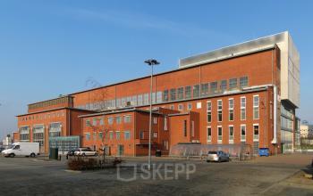 Exterior view of the office building at Helperpark 270-298, Groningen, showcasing its brick façade and large windows available for office space rental.