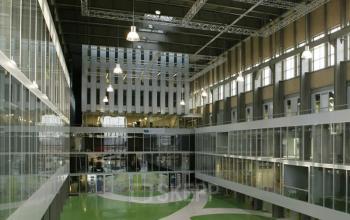 Interior view of Helperpark 270-298 office space in Groningen, featuring glass-walled workspaces and modern lighting.