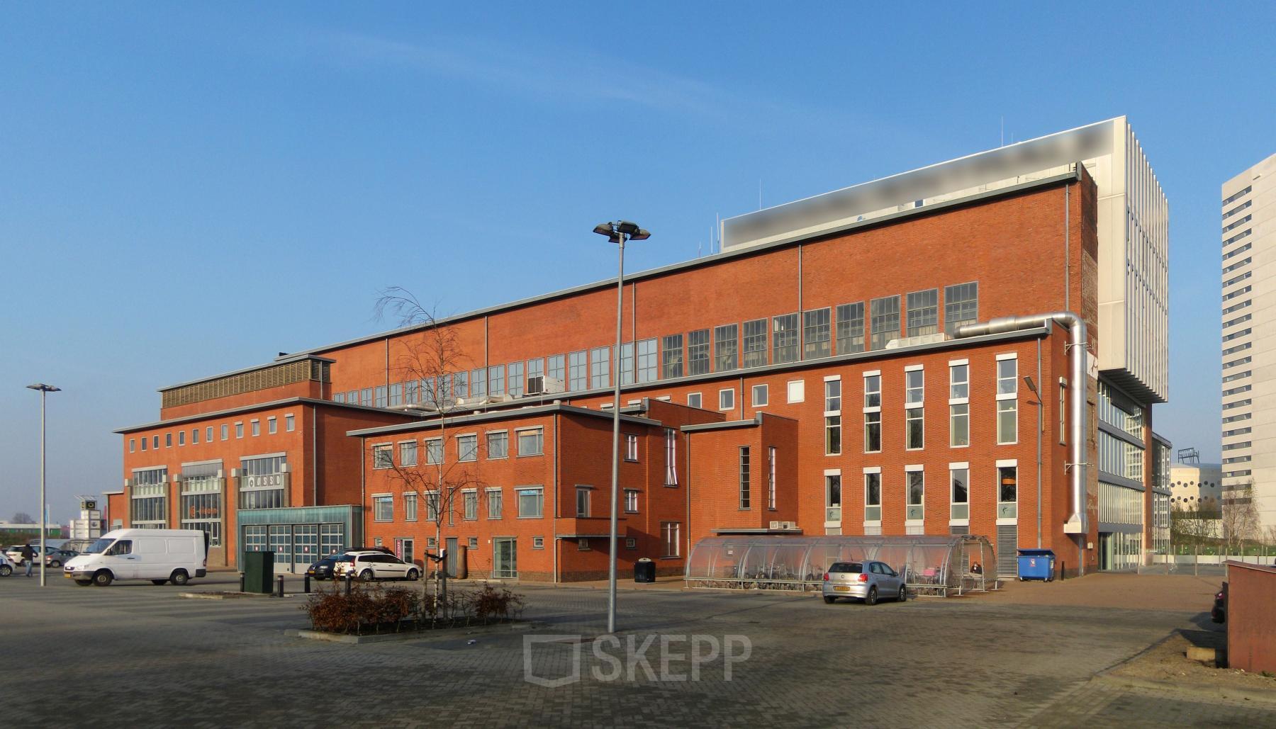 Exterior view of the office building at Helperpark 270-298, Groningen, showcasing its brick façade and large windows available for office space rental.