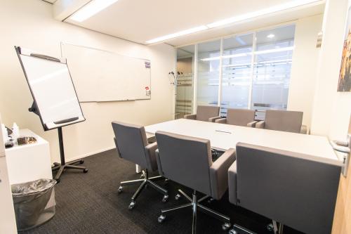 Furnished conference room at Paterswoldseweg 806, Groningen, available for office space rental. Modern design with a central table and chairs, great for meetings.