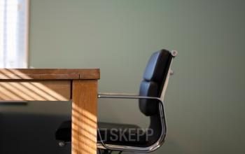 Contemporary office space rental at Kennemerplein 20, Haarlem Centraal Station, featuring a modern desk and chair with ample natural light.