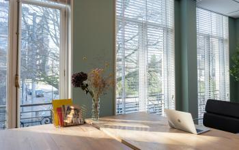 Work-centric environment at Kennemerplein 20, light-filled office space rental in Haarlem Centraal Station with laptop and chair set for productivity.