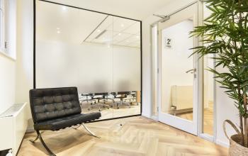 Modern office space rental at Kennemerplein 20, Haarlem Centraal Station, featuring a sleek glass partition and stylish seating.