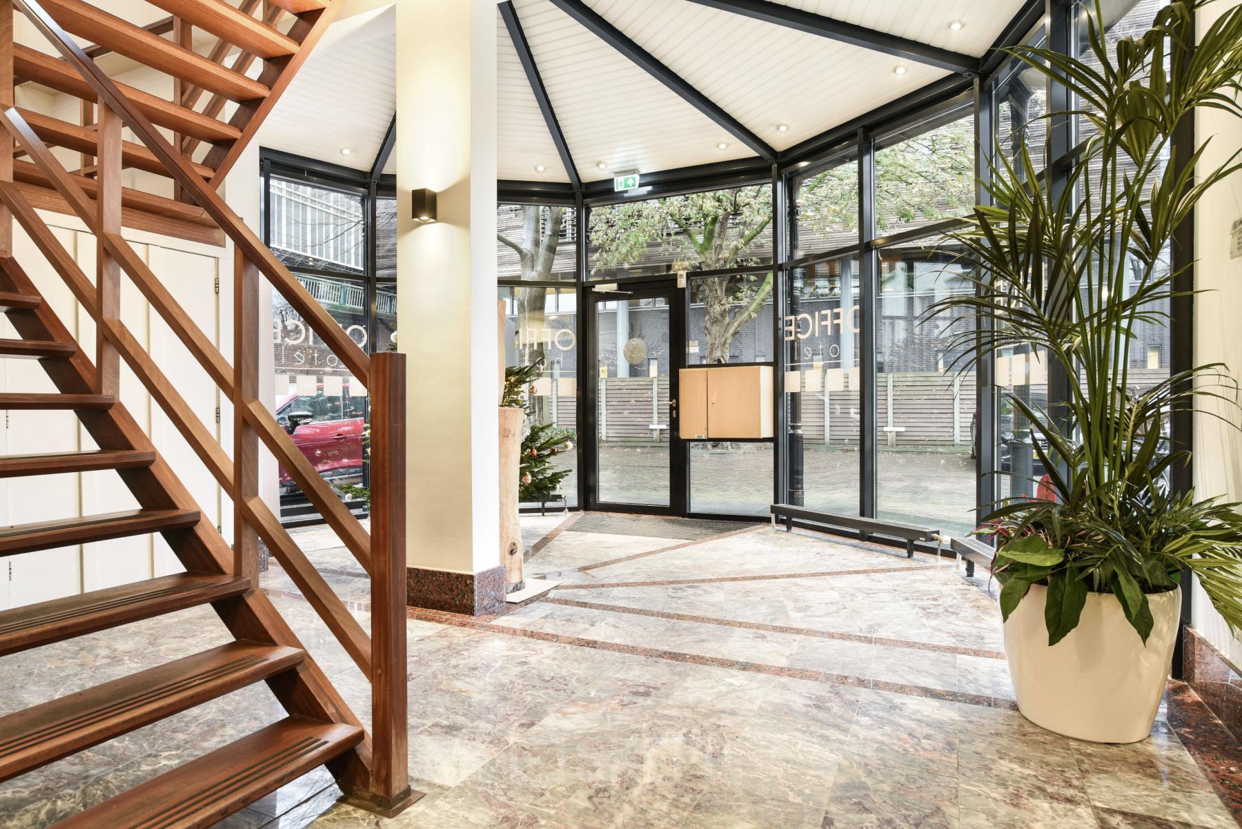 Spacious and well-lit entrance of an office space rental at Kennemerplein 20, Haarlem Centraal Station, showcasing modern design and architectural details.