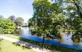 View of serene park with water feature near Prinsen Bolwerk 1, Haarlem Centraal Station, ideal for those seeking office space rental amidst nature.