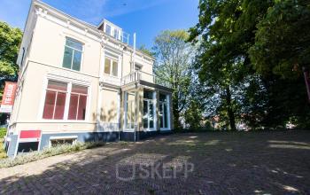 Exterior view of an office available for rent at Prinsen Bolwerk 1, Haarlem Centraal Station, with a charming building and a spacious surrounding area.