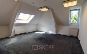 Bright, unfurnished office space available for rent at Prinsen Bolwerk 1, near Haarlem Centraal Station, featuring a large skylight and modern lighting.