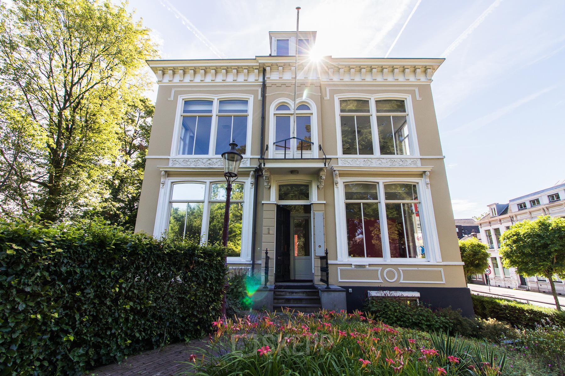 Exterior view of the office to rent at Prinsen Bolwerk 1, Haarlem Centraal Station, featuring a classic facade surrounded by greenery.