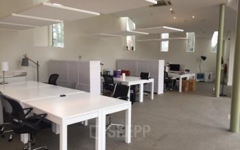 Bright office space with modern white furniture and multiple workstations at Staten Bolwerk 1, Haarlem Centraal Station.