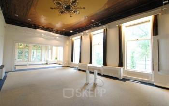 Spacious room with decorated ceiling and large windows at Staten Bolwerk 1, Haarlem Centraal Station for office space rental.