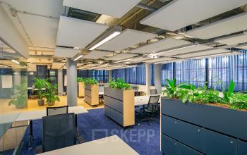 Bright office space at Kennemerplein 6-14, Haarlem Centraal Station with modern furnishings, plants, and desks.
