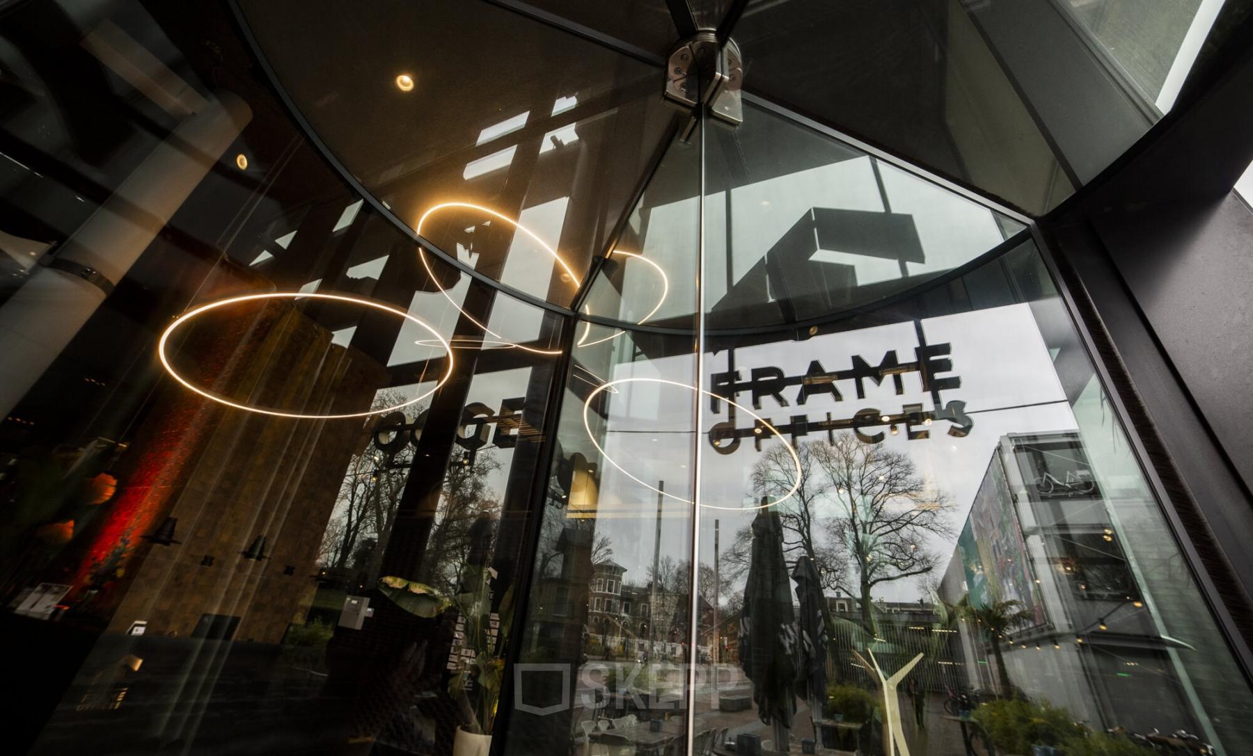 Entrance of the office building at Kennemerplein 6-14, Haarlem Centraal Station, with glass doors and modern signage.
