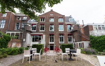 Charming office space rental at Nieuwe Gracht 3, Haarlem Centrum, featuring an outdoor seating area and historic building architecture.