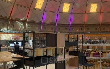 Bright interior at Koepelplein 1E featuring a large domed ceiling, modern open workspaces, and stylish furnishings, perfect for office space rental in Haarlem Centrum.