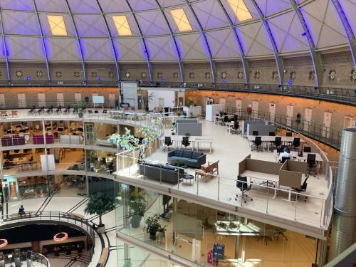 Bright, open office space rental at Koepelplein 1E, Haarlem Centrum, featuring modern workstations and elegant meeting areas under a striking domed roof.