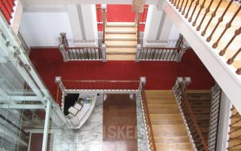 Bright office entrance at Wilhelminastraat 43A in Haarlem Centrum with stairs, red carpet, and a reception desk for office space rental.