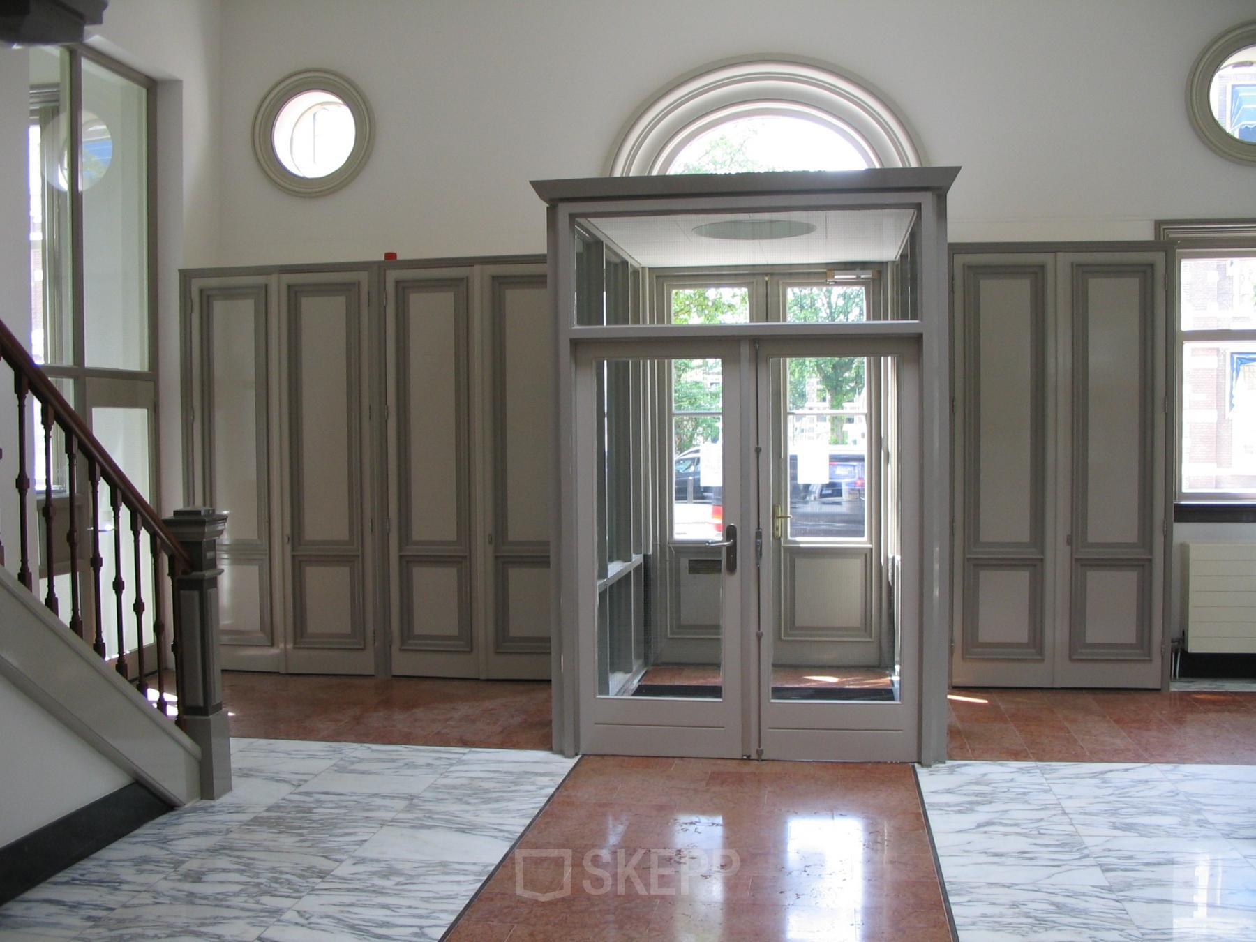 Elegant entrance with marble flooring and large windows located at Wilhelminastraat 43A, Haarlem Centrum, Haarlem, suitable for office space rental.