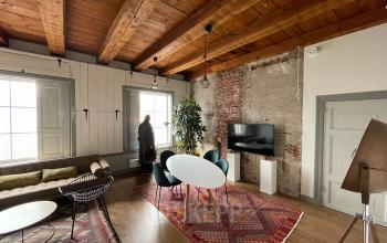 Cozy Haarlem Centrum office to rent with wooden ceiling, exposed brick walls, modern furniture, and large windows at Nieuwe Gracht 74-76.