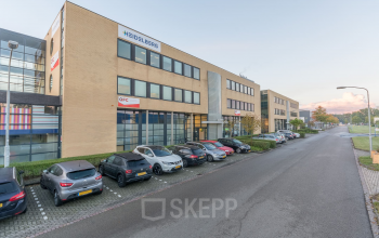 Exterior view of office building at Mollerusweg 84, Haarlem Waarderpolder, Haarlem with parking spaces and multiple parked cars in front.