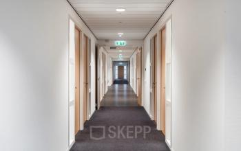 Long, well-lit corridor at Mollerusweg 84 in Haarlem Waarderpolder, ideal for office space rental with multiple doors leading to rental office spaces.