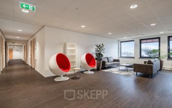 Modern, brightly lit office lounge with unique seating and comfortable couches, located at Mollerusweg 84, Haarlem Waarderpolder. Ideal office space rental for a creative and inviting atmosphere.