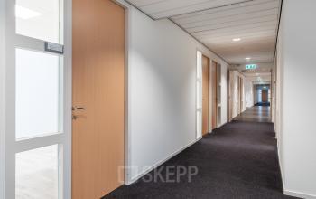 A hallway in an office building at Mollerusweg 84, Haarlem Waarderpolder, ideal for office space rental with several closed doors along the corridor.