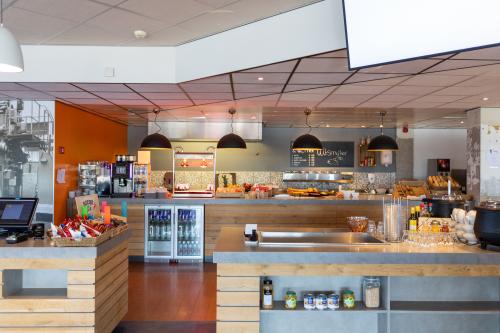 Pantry area in Mollerusweg 84 office building, Haarlem Waarderpolder. Equipped with food and beverage stations, ample lighting, and modern fixtures for office space rental.