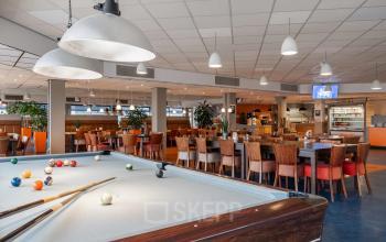 Spacious, vibrant office space available for rent at A. Hofmanweg 5A in Haarlem Waarderpolder, featuring a pool table and dining area.